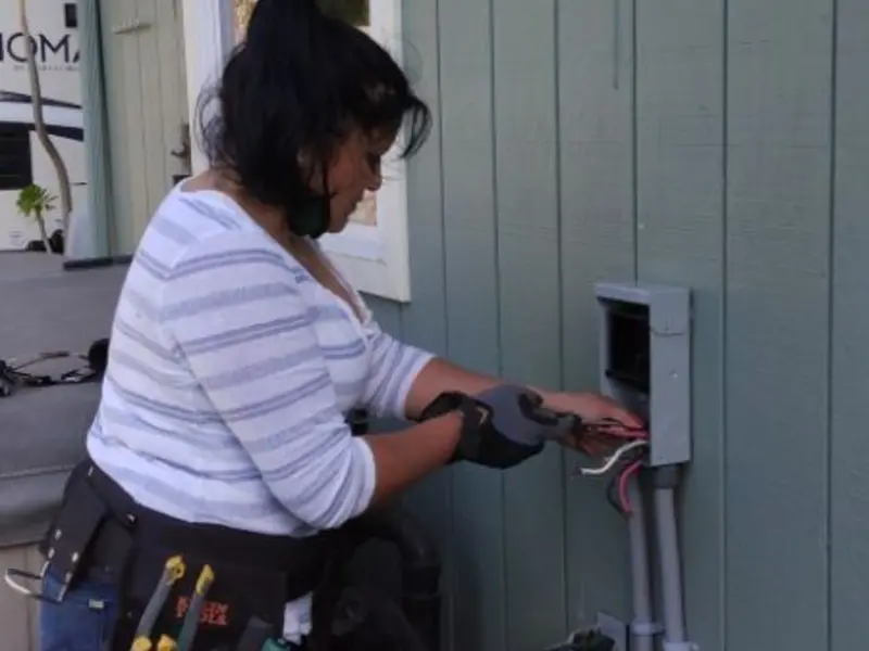Licensed electrician wiring an exterior subpanel in California